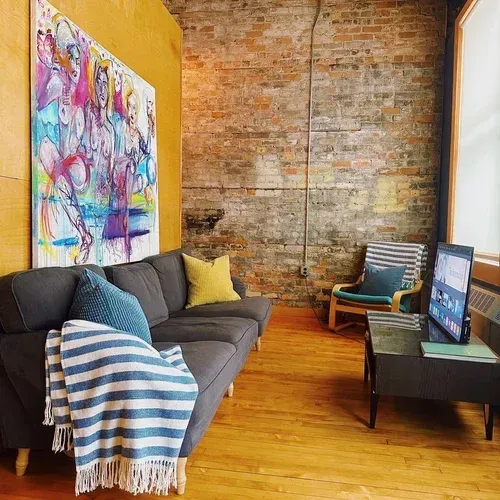 Lounge corner with exposed brick wall and colorful local art